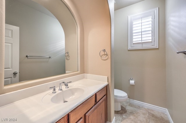 bathroom with tile patterned flooring, vanity, and toilet