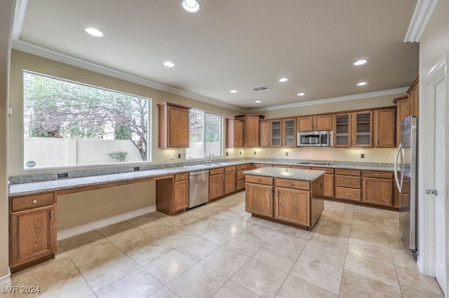 kitchen featuring a center island, crown molding, sink, and appliances with stainless steel finishes