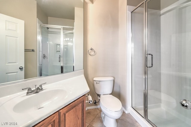 bathroom featuring tile patterned flooring, vanity, a shower with shower door, and toilet