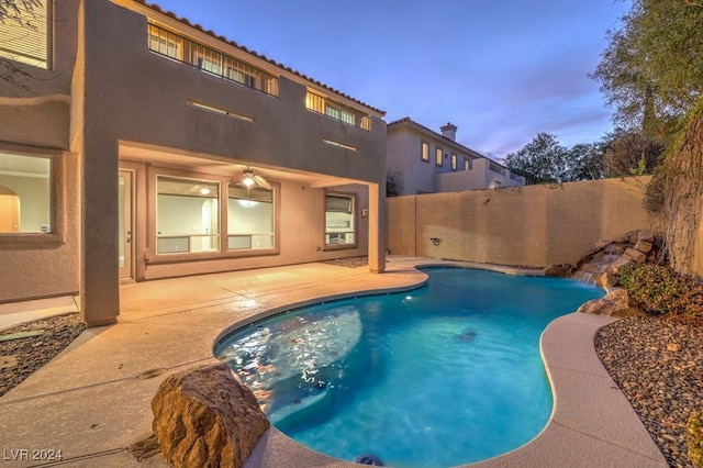 pool at dusk featuring a patio area