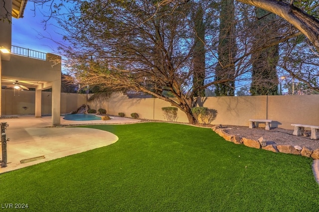 view of yard featuring a patio, a fenced in pool, and ceiling fan