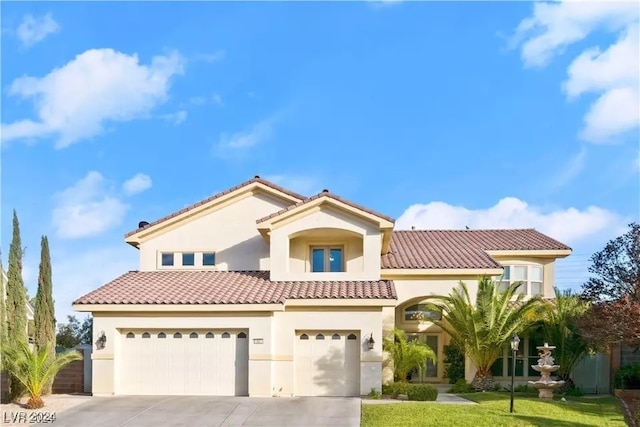 mediterranean / spanish-style house featuring a garage and a front lawn