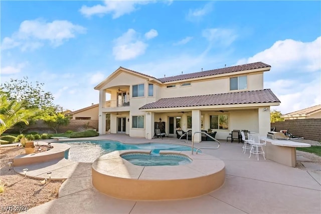 back of property featuring a swimming pool with hot tub, a balcony, a patio, and ceiling fan