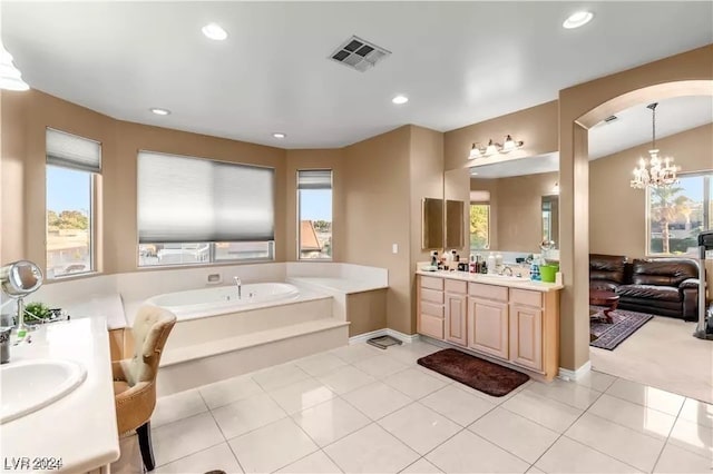 bathroom featuring vanity, a washtub, tile patterned flooring, and a notable chandelier