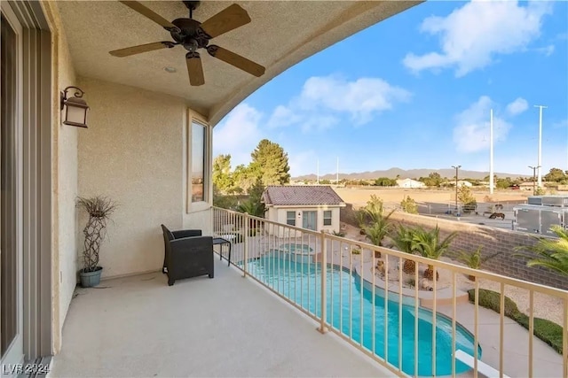 balcony with a mountain view, a patio, and ceiling fan