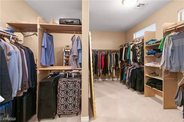 walk in closet featuring light colored carpet