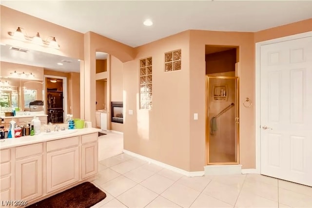 bathroom featuring walk in shower, vanity, and tile patterned flooring