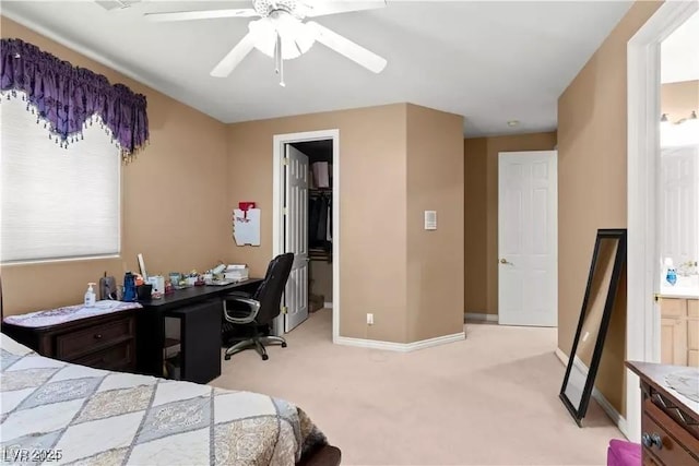 carpeted bedroom featuring a walk in closet and ceiling fan