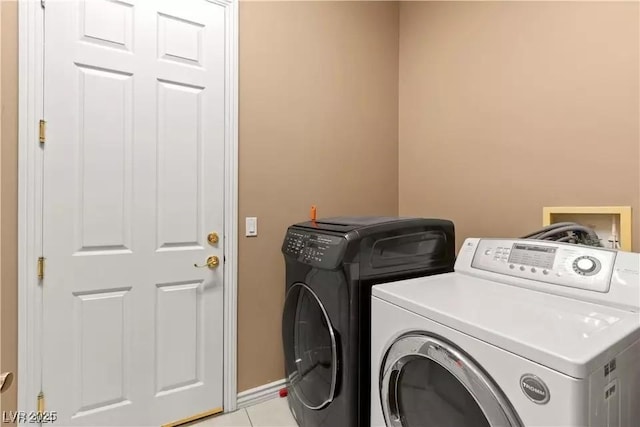 washroom with light tile patterned floors and washer and clothes dryer