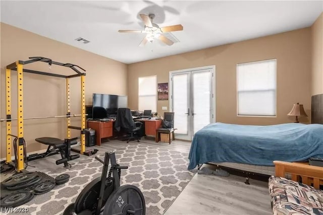 bedroom with ceiling fan, light hardwood / wood-style floors, and french doors