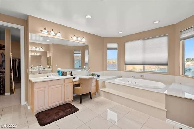 bathroom featuring vanity, tile patterned flooring, plenty of natural light, and a tub