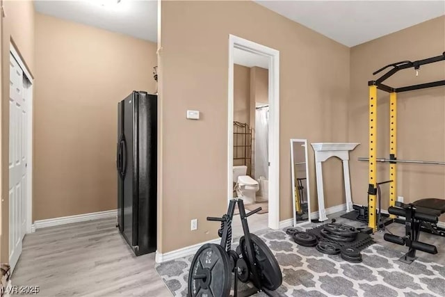 exercise room with light hardwood / wood-style flooring