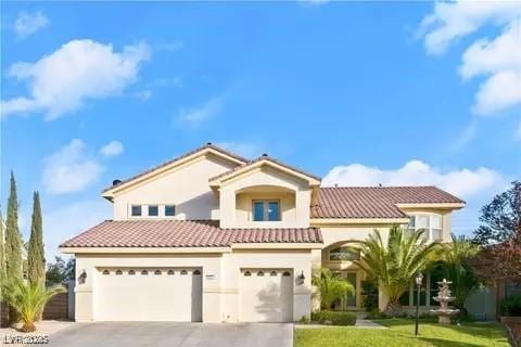 mediterranean / spanish-style home featuring a garage and a front yard