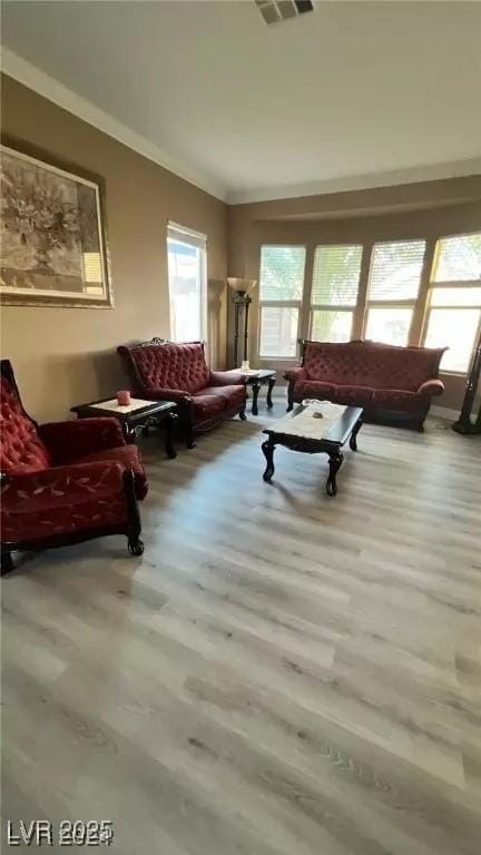 living room with light hardwood / wood-style flooring and ornamental molding