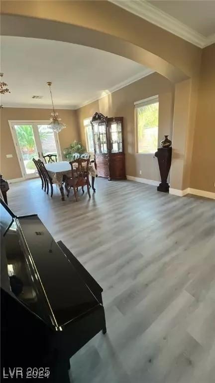 dining area with hardwood / wood-style flooring, crown molding, and a wealth of natural light