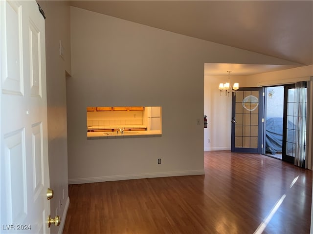 unfurnished living room with dark hardwood / wood-style flooring, high vaulted ceiling, and a chandelier