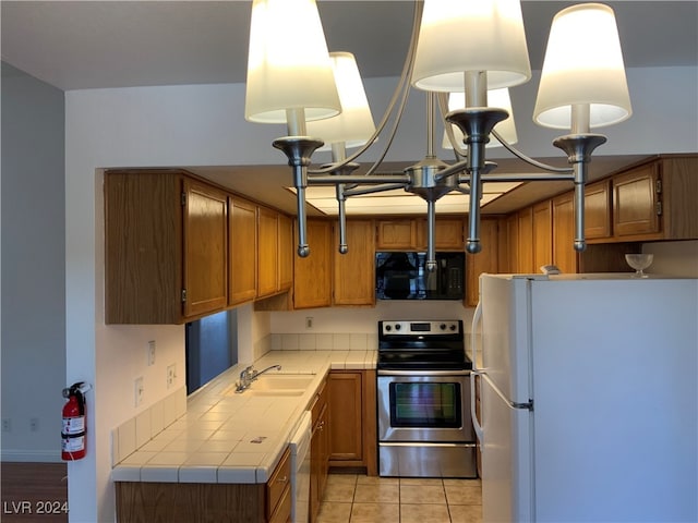 kitchen with stainless steel range with electric stovetop, white refrigerator, sink, dishwashing machine, and light tile patterned flooring