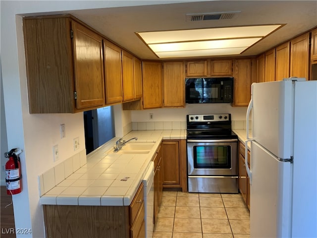 kitchen with white appliances, sink, and light tile patterned floors