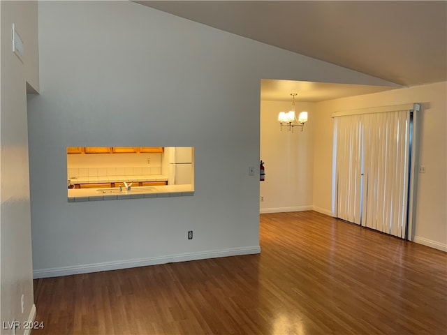 unfurnished living room featuring lofted ceiling, sink, a chandelier, and dark hardwood / wood-style floors