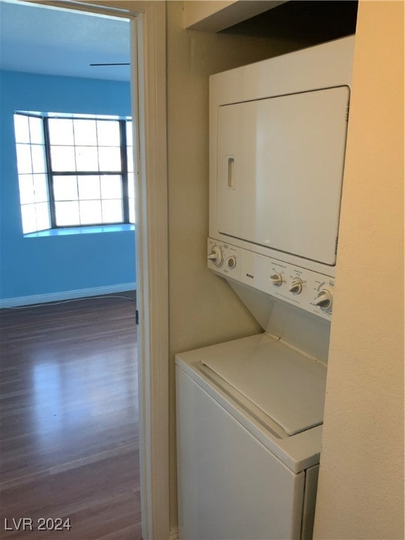 washroom featuring dark hardwood / wood-style floors and stacked washer / dryer