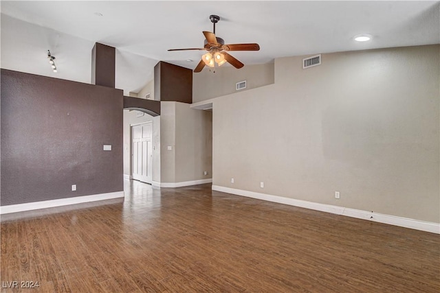 spare room with dark wood-style floors, visible vents, baseboards, and a ceiling fan