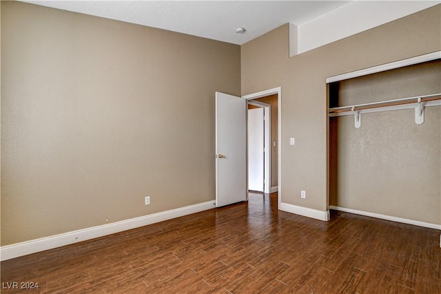 unfurnished bedroom featuring a closet, baseboards, and wood finished floors