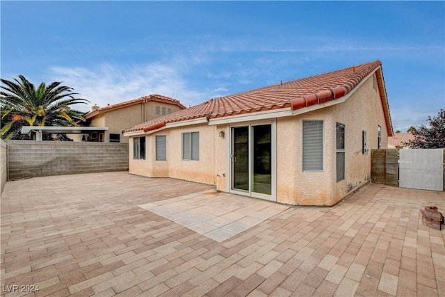 back of house with a patio, a tiled roof, and stucco siding