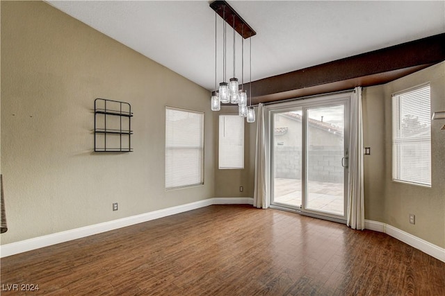 empty room featuring dark wood-type flooring, lofted ceiling, and baseboards