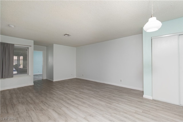 interior space featuring a textured ceiling and light hardwood / wood-style flooring