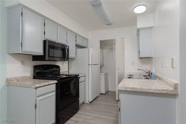 kitchen with white fridge, light hardwood / wood-style flooring, sink, and black electric range