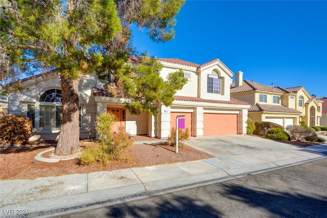 mediterranean / spanish-style home with a garage