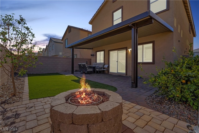 patio terrace at dusk featuring a fire pit