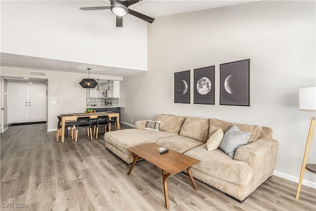 living room with wood-type flooring and ceiling fan