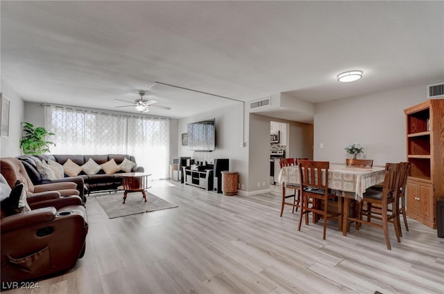 living room with light hardwood / wood-style flooring and ceiling fan