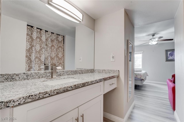 bathroom featuring ceiling fan, vanity, and wood-type flooring