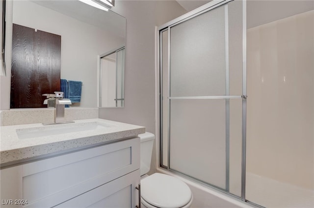 bathroom featuring toilet, an enclosed shower, and vanity