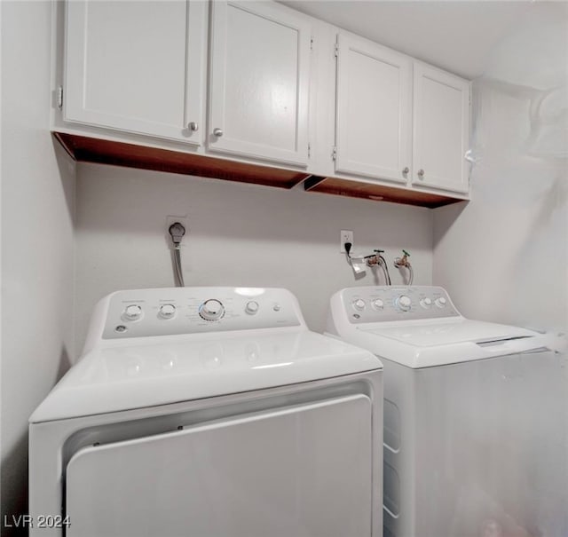 washroom featuring cabinets and separate washer and dryer