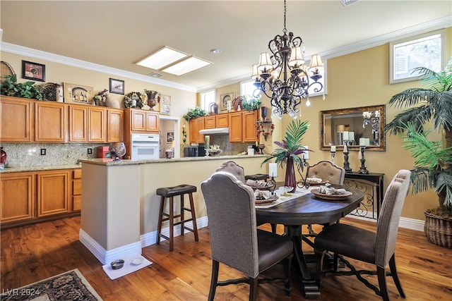 dining room featuring ornamental molding, dark wood-type flooring, and an inviting chandelier