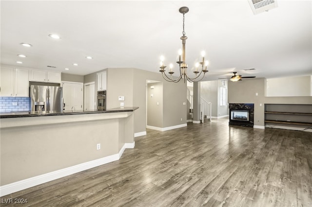 unfurnished living room featuring a fireplace, ceiling fan with notable chandelier, and hardwood / wood-style flooring