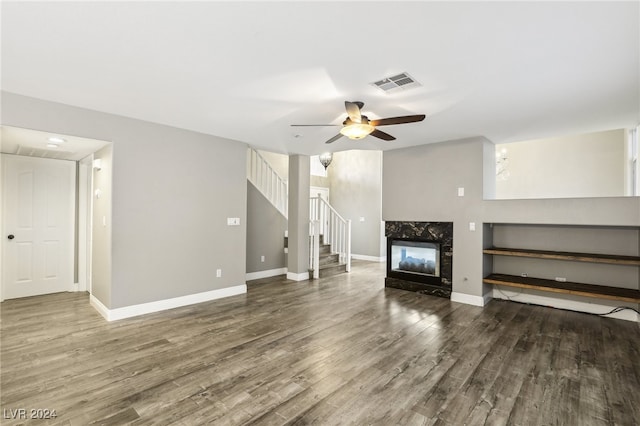 unfurnished living room with ceiling fan, dark hardwood / wood-style flooring, and a high end fireplace