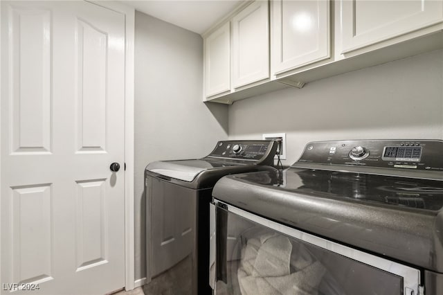 washroom featuring cabinets and washing machine and dryer