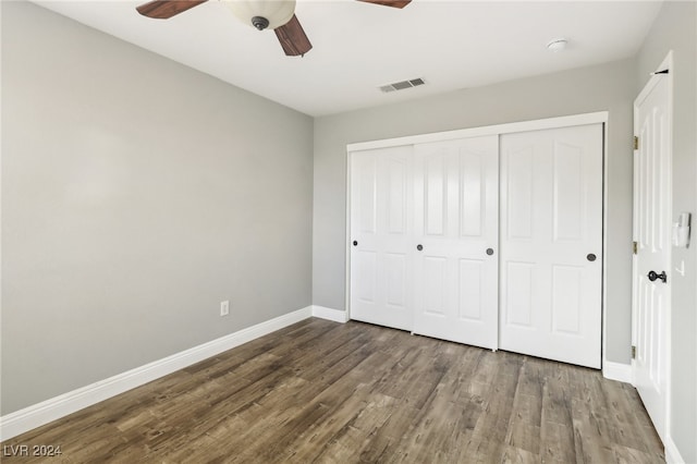 unfurnished bedroom with ceiling fan, dark hardwood / wood-style flooring, and a closet