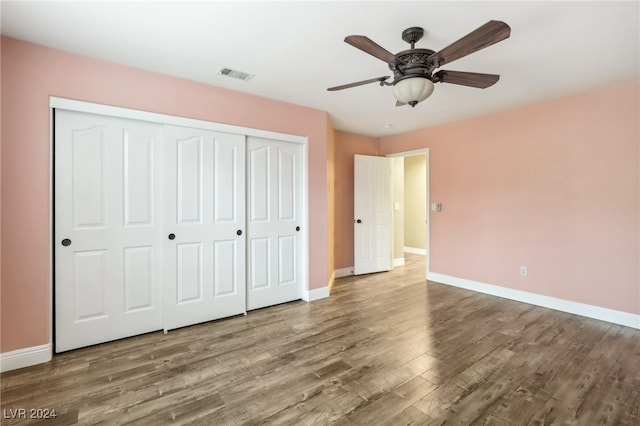 unfurnished bedroom with hardwood / wood-style floors, ceiling fan, and a closet