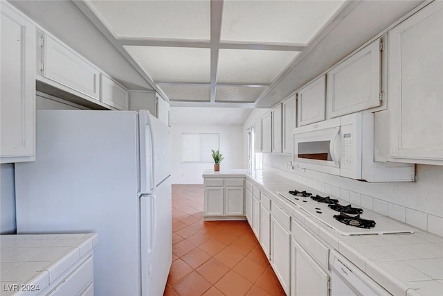 kitchen featuring white cabinetry, tile counters, and white appliances