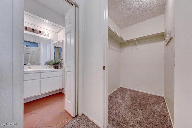 walk in closet with light tile patterned flooring and light colored carpet