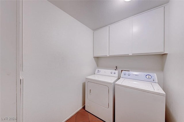 laundry area with light tile patterned flooring, cabinet space, and washing machine and clothes dryer