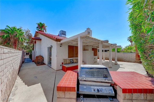 rear view of property featuring a patio area, stucco siding, central AC, and a fenced backyard