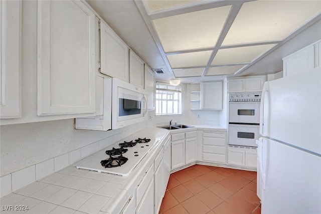 kitchen with white cabinets, white appliances, and tile counters