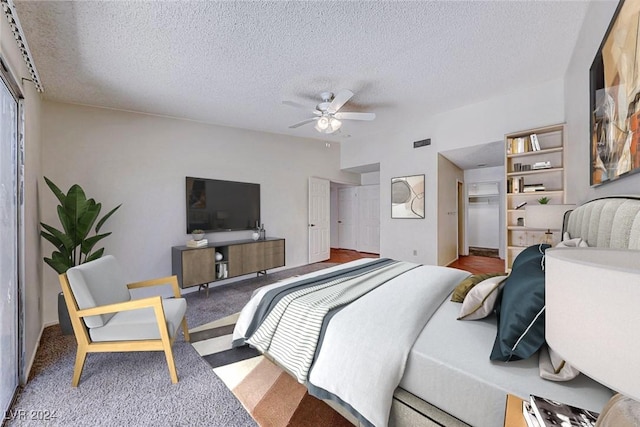 carpeted bedroom featuring a closet, a textured ceiling, a ceiling fan, and vaulted ceiling