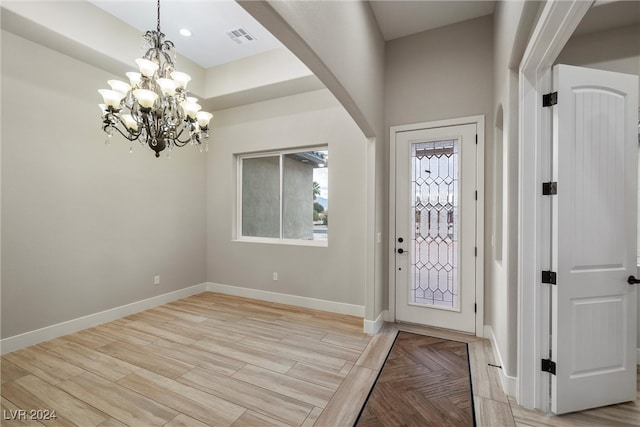 foyer entrance featuring light hardwood / wood-style floors and an inviting chandelier